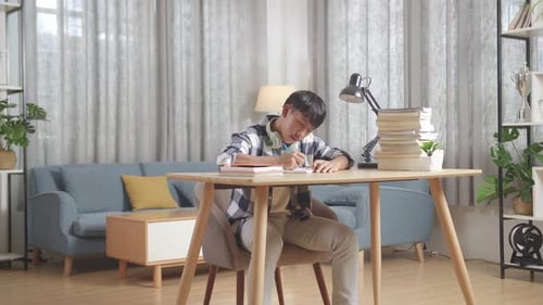 Asian Teenager Studying At Home, Asia Teen Writing While Sitting On The Table