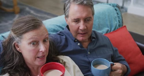 Couple Relaxing on Couch at Home with Drinks