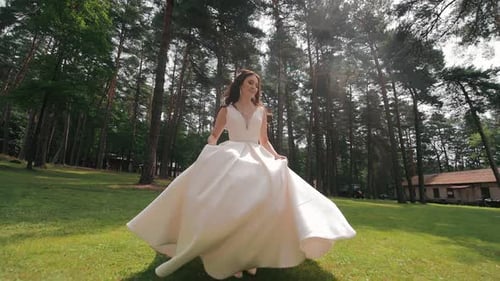 Happy Bride Jogging in the Park and Smiling at the Camera Wedding Walk of the Bride in the Park