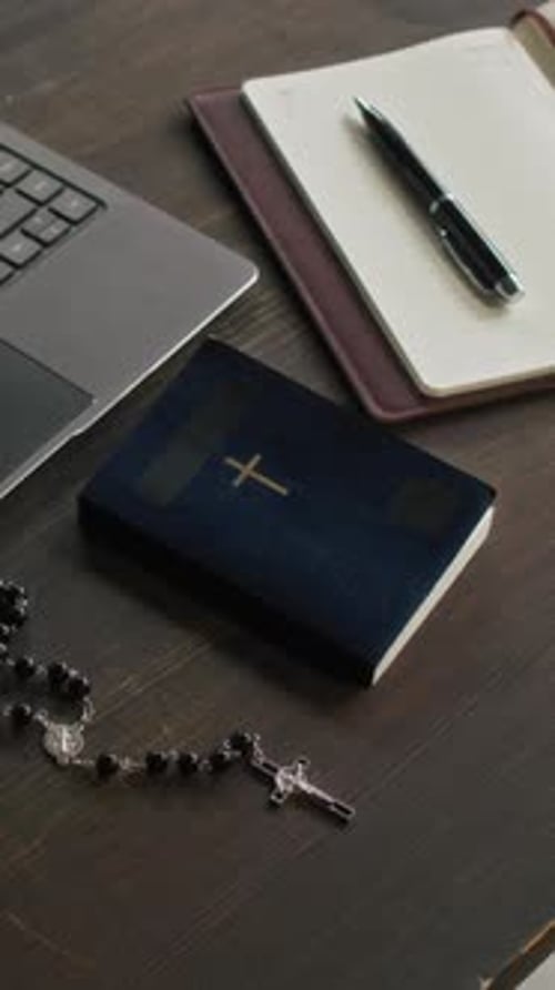 Vertical Video of Book and Rosary on Table