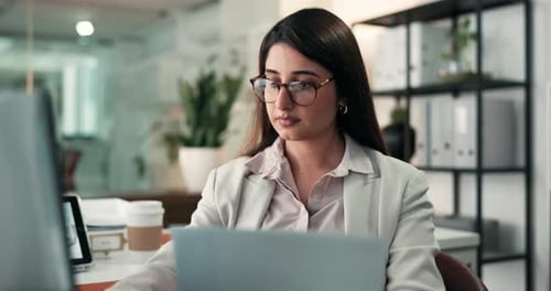 Woman Works at Desk with Documents and Laptop