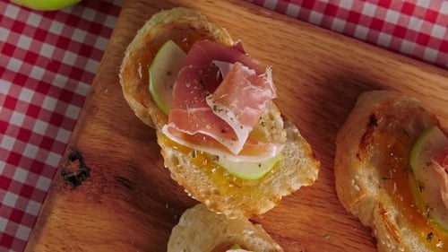 Pintxos, tapas espagnoles de jambon serrano sur une planche de chêne américain, fond de table à carreaux