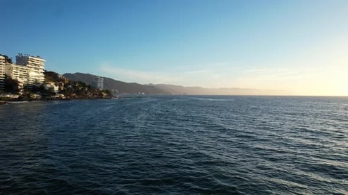 blue ocean at sunset along Puerto Vallarta mountain coastline in Mexico, aerial