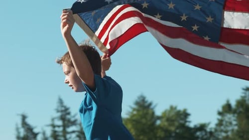 Boy Holding American Flag Outside on Sunny Day