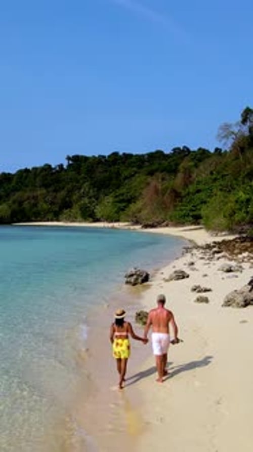 Couple Walks Hand in Hand Along the Pristine Shores of Koh Kradan Thailand