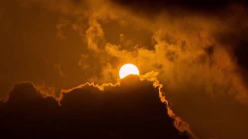 Majestic Sun Rising Behind Ominous Clouds
