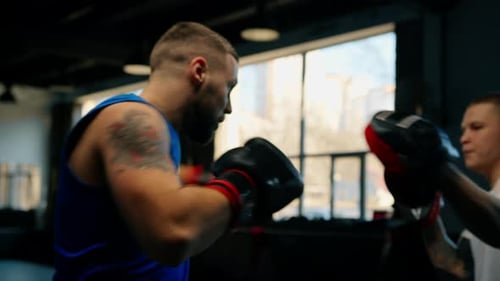Boxer Practices His Punches with His Coach in the Boxing Gym