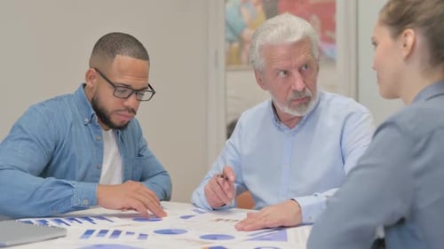 Diverse Team Collaborates Analyzing Data in Office Setting