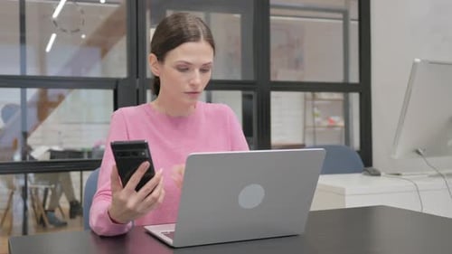 Woman Works On Laptop And Using Smartphone