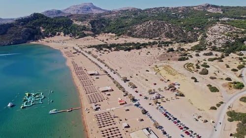 Aerial view of a sandy beach with umbrellas and sunbeds on a sunny day