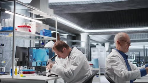 Male Science Expert Operates with Microscope and Laboratory Tray