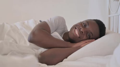 Man Lying in Bed Smiling and Relaxing