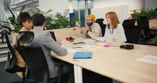 Diverse Professionals Collaborate Sitting at Table in Office