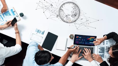 Equipo diverso que colabora en el análisis de datos y las estrategias digitales utilizando una computadora portátil, gráficos y diagramas