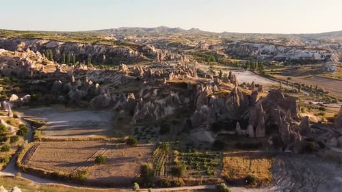 Aerial shot approaching rock formation in Cappadocia during golden hour