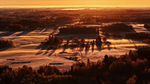 Drone Tracking Along Farmlands at Sunset With Long Silhouettes and Shadows