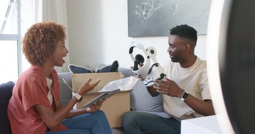 Couple déballant la boîte livrée sur le canapé, la tablette de lecture et assemblant le casque blanc pour l'installation