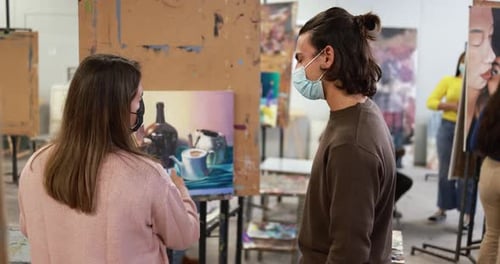 Art students painting still life in art class