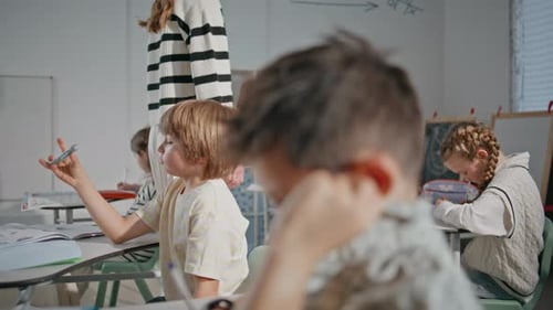 Teacher Assists Students in Classroom Setting