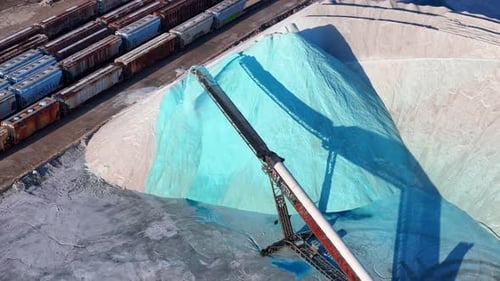 Conveyor Moving Bright Blue Salt in Industrial Depot of Detroit Michigan US, aerial view from above