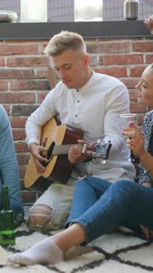 Friends Enjoying Pizza and Music on Rooftop Patio