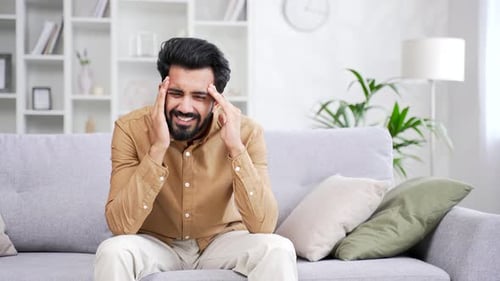 Man Experiencing Headache in Living Room