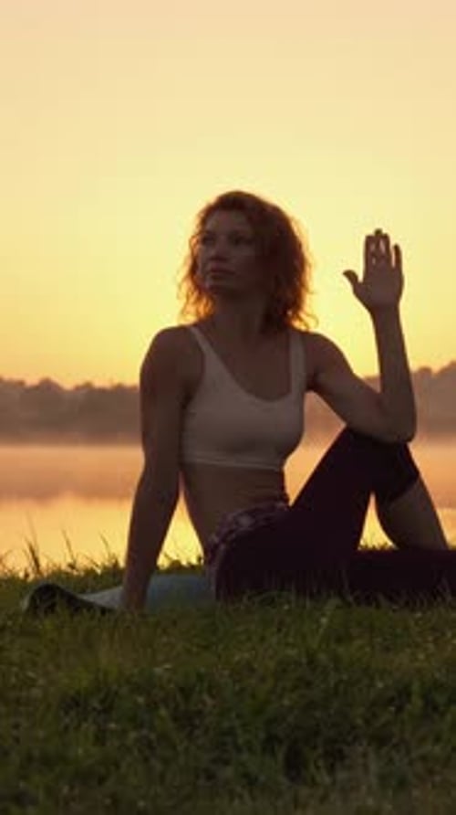 Portrait of a Woman Relaxing Practicing Yoga on the Shore of a Lake Enjoying the Tranquility and