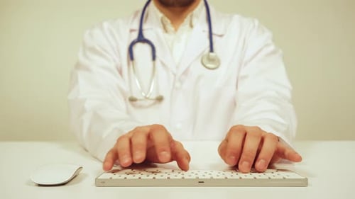 Arzt tippt auf der Tastatur