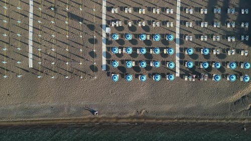 Aerial view of the sea and beach with beach umbrellas and turquoise clear water.