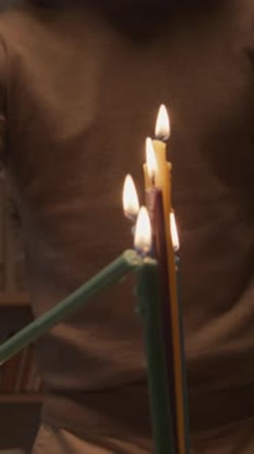 Hand of Jewish Man Lighting up Candles on Hanukkah