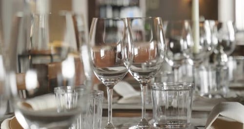A waiter sets the table in a restaurant before customers arrive, and uses fine cutlery and glasses