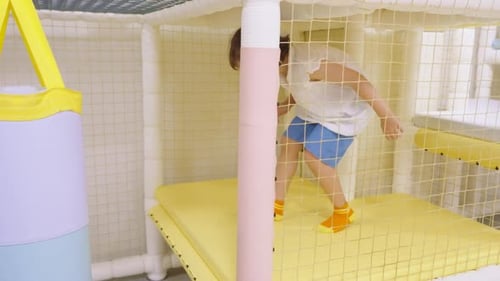 Little Girl Navigating Obstacle Course in Indoor Playground Slow Motion