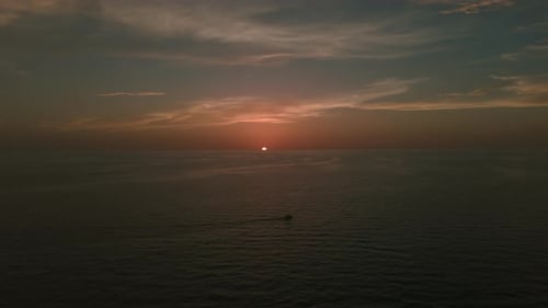 Cinematic Aerial Wide View of a Boat Sailing s on Deep Blue Water on Sunset Time