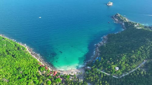 Sandy beach shore with beautiful resort surrounded by clear sea water.