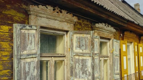 Verwitterte Holzfenster mit kunstvollen Schnitzdetails