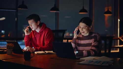 Young Adults Working on Laptops, Talking on Phone at Night
