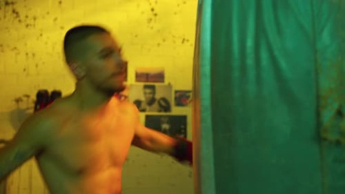 Focused Man Punches Heavy Bag in Boxing Training