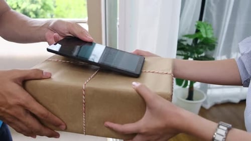 Delivery Person Hands Package to Woman for Signature