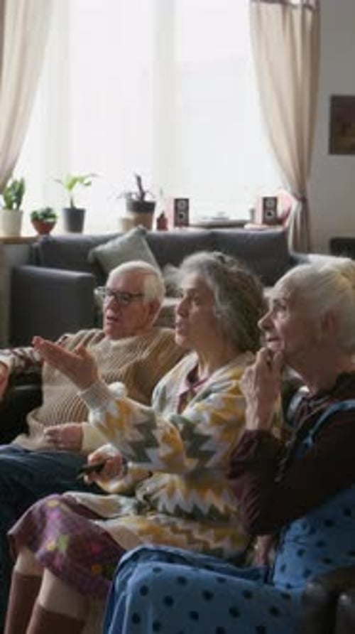 Seniors Chatting on Couch Indoors During Daytime