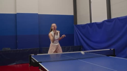 Young Woman Stroking Loop Shot while Playing Table Tennis in Gym