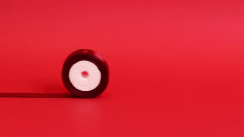 Satin Ribbon Roll on Red Background