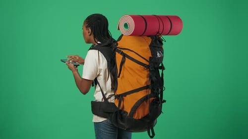 Woman with Backpack Navigating with Smartphone on Green Screen