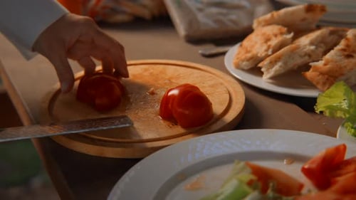 Close-up of chef slicing tomatoes on board