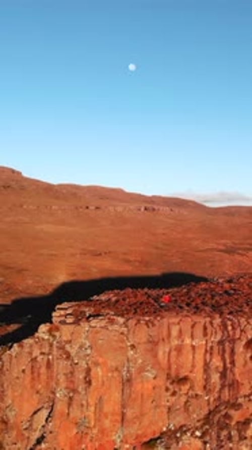 Early Morning Light Reveals Uneven Rocky Terrain While Geologist Carefully Studies Horizon