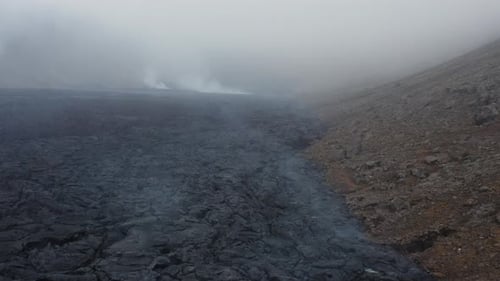 Freshly formed earth surface with black basalt rock in Iceland, cloudy