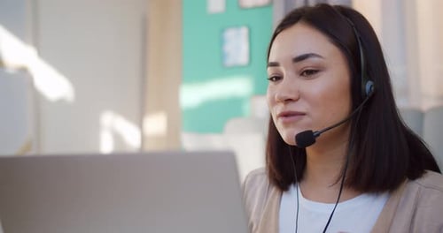 Woman Using Headset on Video Call With Laptop