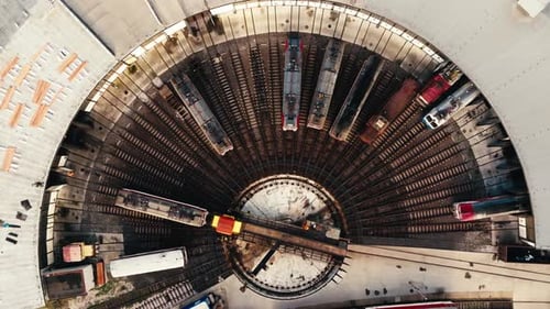The yellow locomotive leaves the depot. Railway turntable for locomotives - Aerial clip. Top shot of