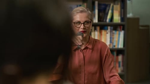 Author Speaking into Microphone during Bookstore Reading Event