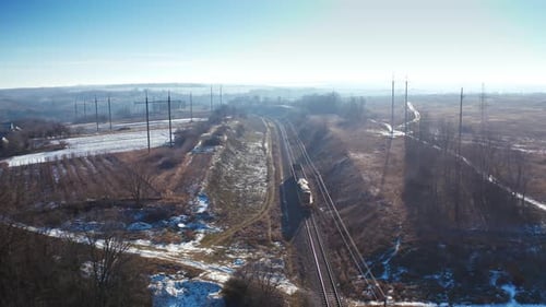 View from above on a freight train. Small cargo train moving on railroad in a sunny winter day.