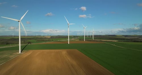 Wind Turbines Rotating in Vast Green Rural Landscape